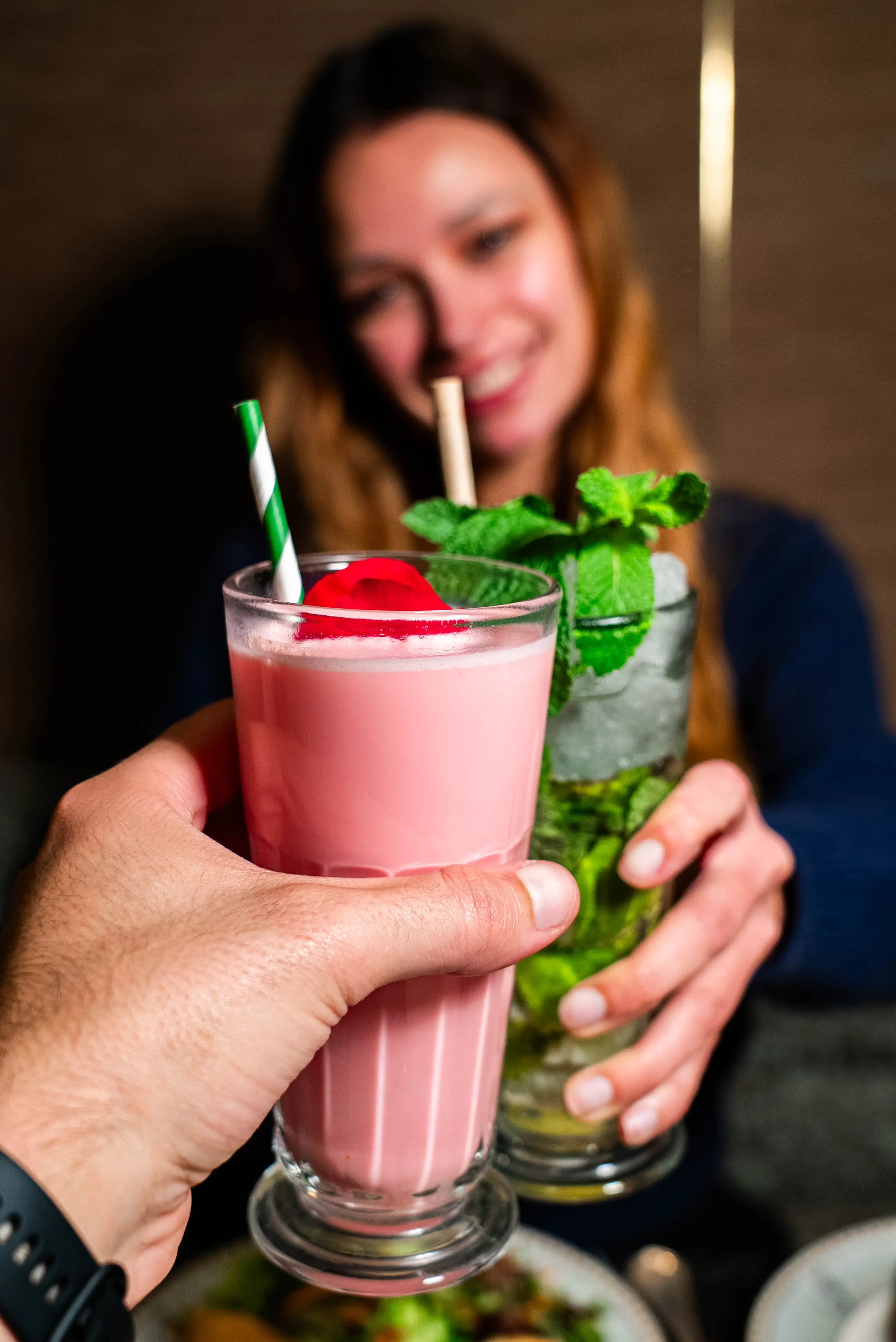 Zwei Gäste stoßen mit Drinks in entspannter Atmosphäre an