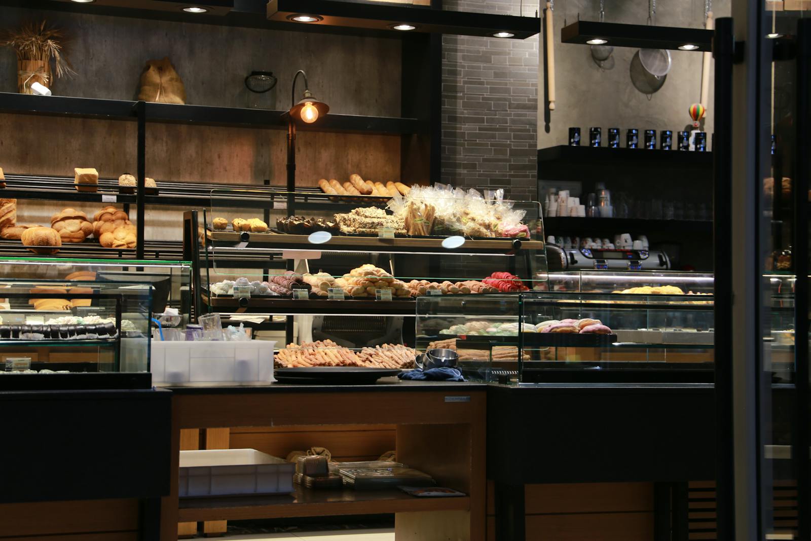 Einladendes Bäckerei-Interieur mit Auslage voller frischem Brot und Gebäck in warmem Licht.