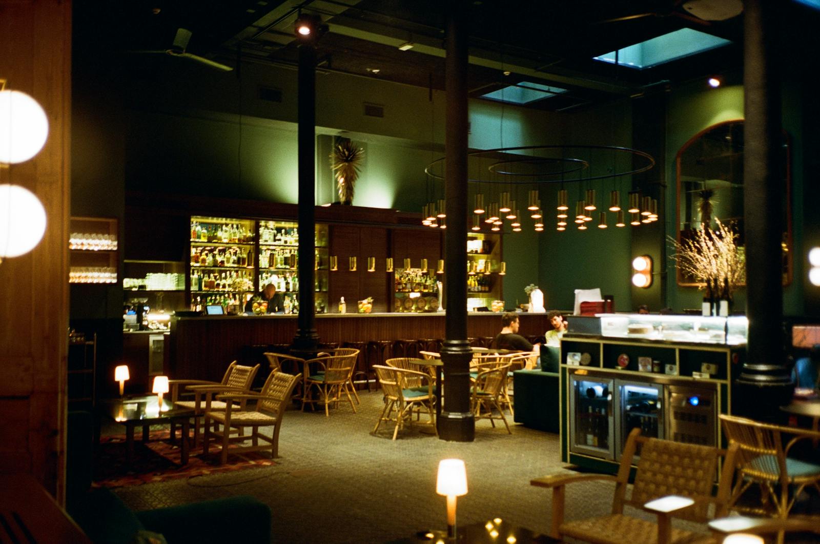 Stilvolle Bar mit warmem Licht, halbleeren Sesseln und gedämpfter Abendstimmung.