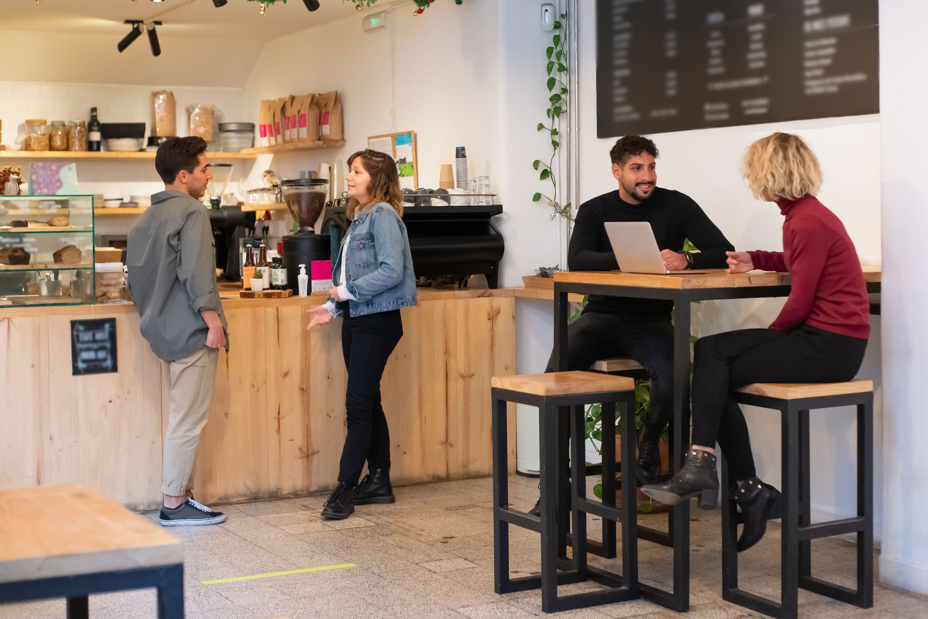 Gäste unterhalten sich bei Getränken in einem gemütlichen Café.